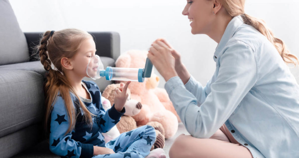 Madre con un niño que usa un inhalador