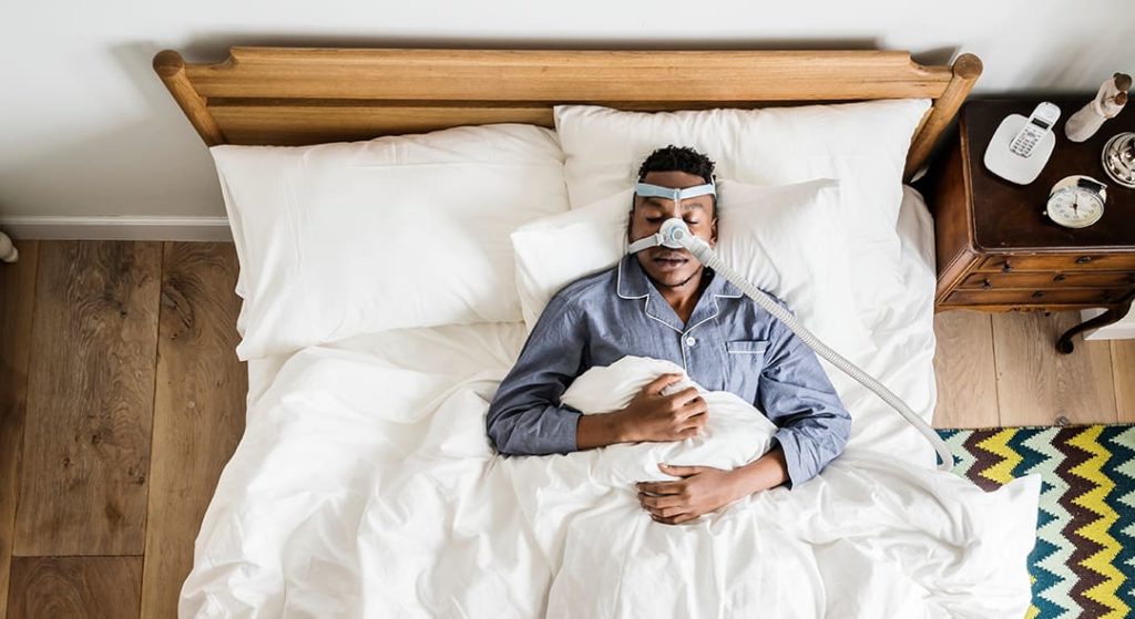 hombre con máquina para la apnea del sueño