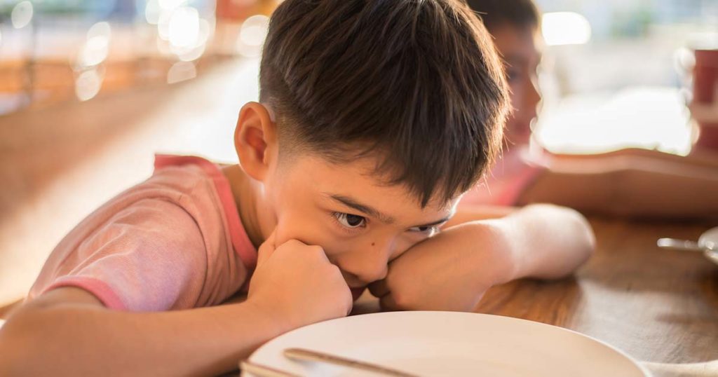 Un niño en la escuela está lleno de ansiedad por sus alergias alimentarias