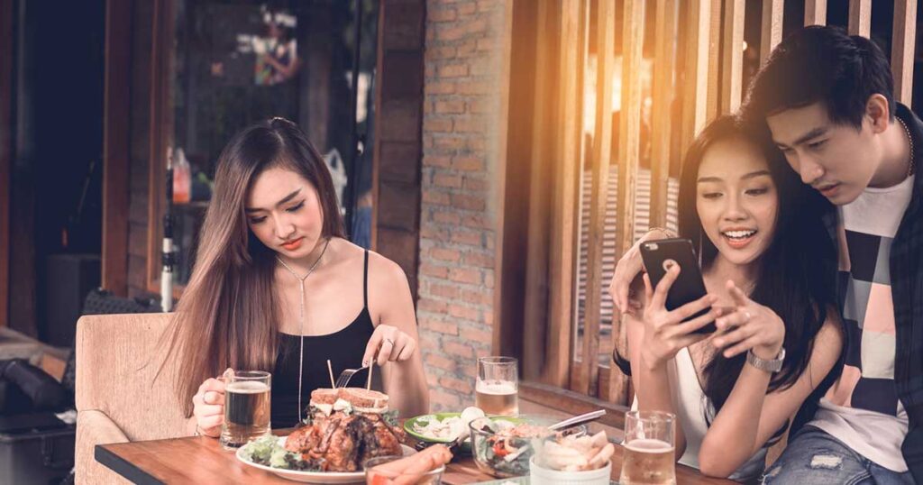 Mujer comprobando si hay alérgenos alimentarios en un restaurante.