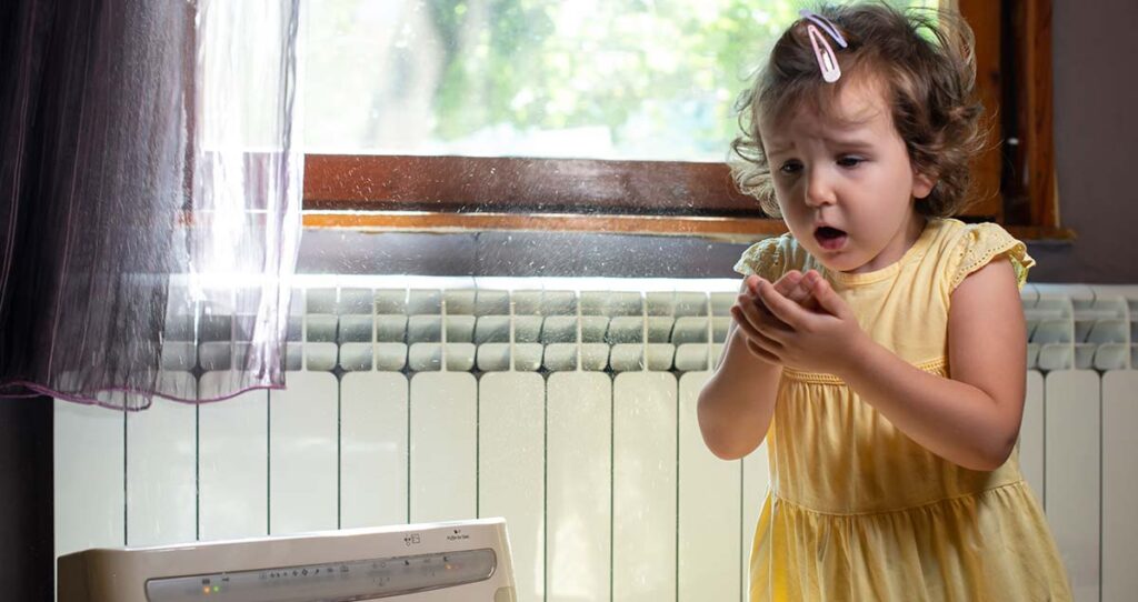Imagen de una niña tosiendo debido a la contaminación en interiores.