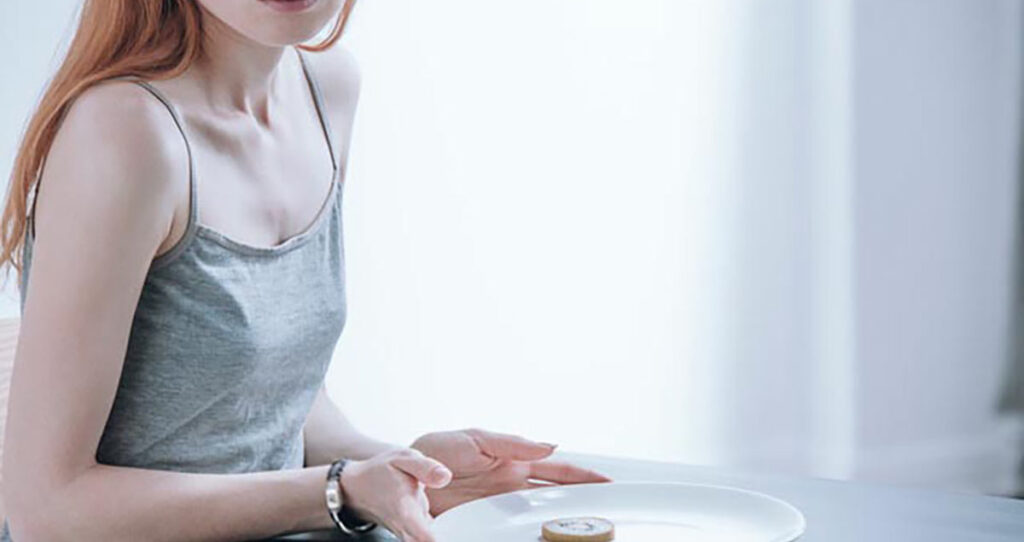adolescente con ansiedad alimentaria sosteniendo un plato con un kiwi