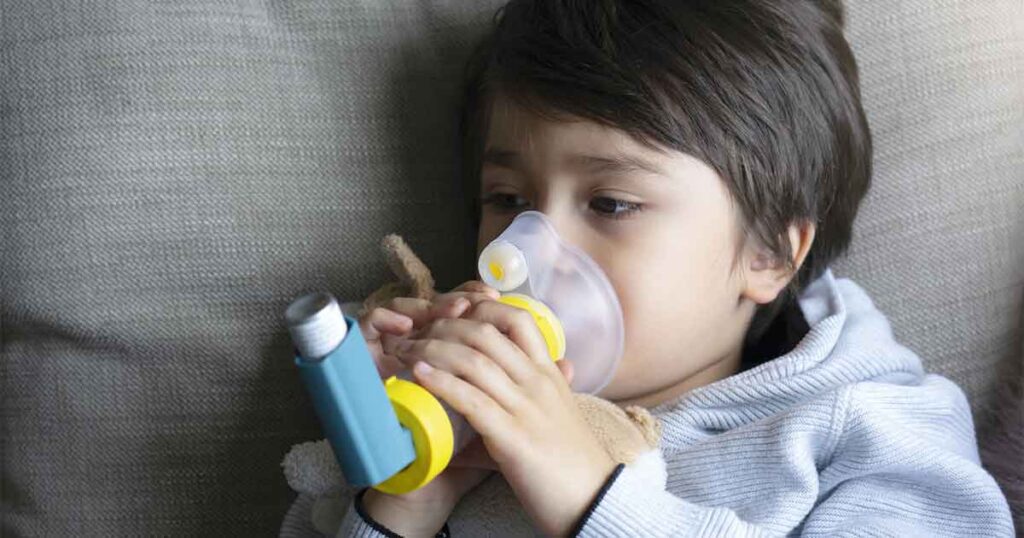 niño con cámara espaciadora para el asma