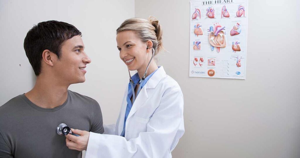 Una médica examina a un paciente varón por problemas cardíacos debidos a una enfermedad de mastocitos.