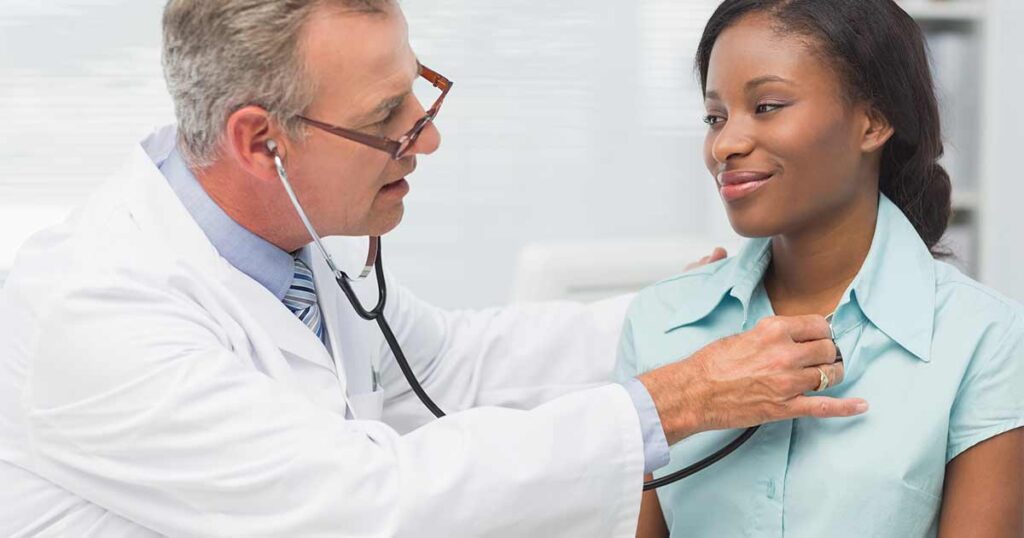 Un médico examina a una paciente por problemas respiratorios debidos a la enfermedad de mastocitos.
