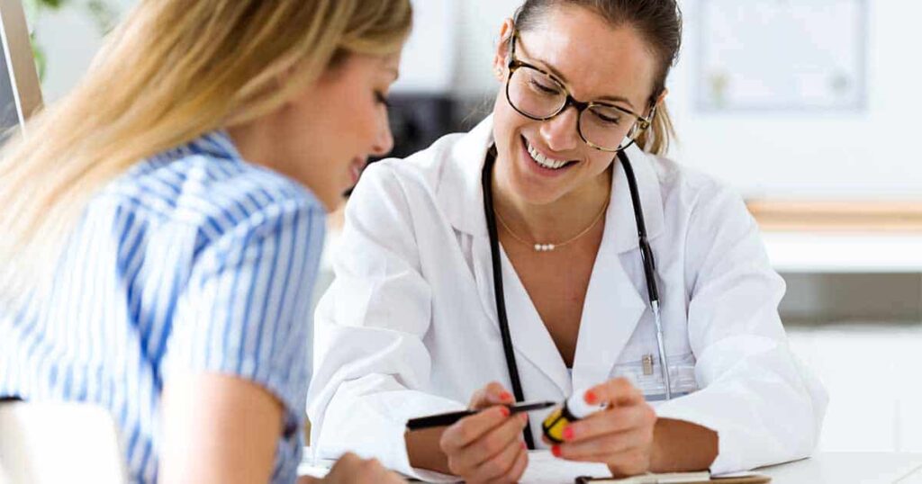 Mujer médico mostrando opciones de tratamiento a una paciente con una forma de enfermedad de mastocitos.