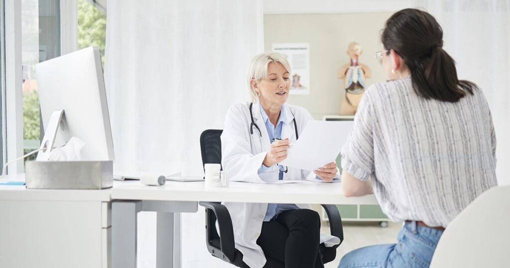 médica atendiendo a una mujer en su consultorio