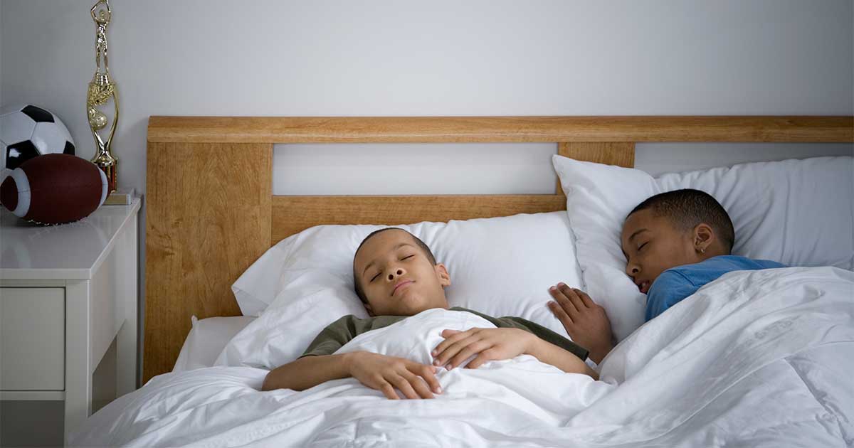 Dos chicos preadolescentes durmiendo por la mañana tras haber pasado la noche en vela debido a problemas de asma.